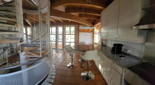 巴林根Architektenhaus Albblick的厨房配有白色橱柜和木制天花板