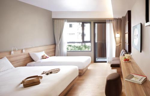 曼谷快乐3号酒店的酒店客房设有两张床和窗户。