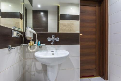拉多姆Hotel Poniatowski的浴室设有白色水槽和镜子