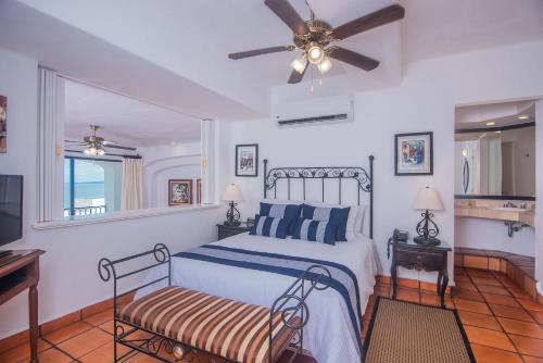 巴亚尔塔港One Beach Street Puerto Vallarta的一间卧室配有一张床和吊扇