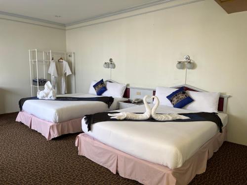 合艾梅林大酒店的两张床铺,位于酒店客房内,配有天鹅
