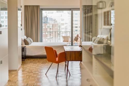安特卫普Fuths Loft Penthouse 85的酒店客房带一张床、一张桌子和椅子