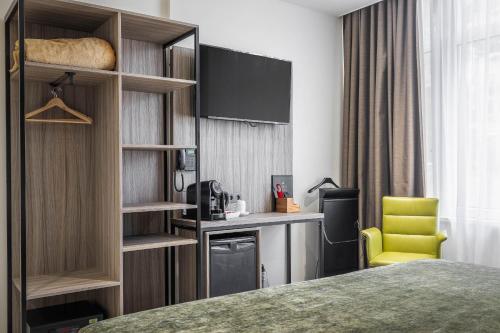 鹿特丹米兰诺酒店的酒店客房,配有床和黄色椅子