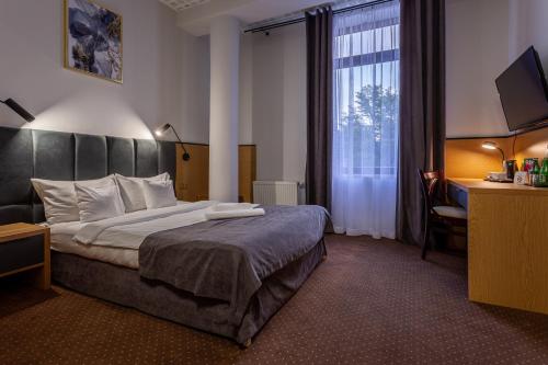 拉多姆Hotel Poniatowski的酒店客房设有床和窗户。