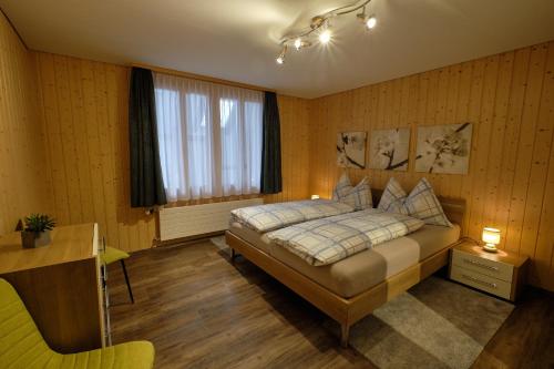 瓦森Ferienwohnung的一间卧室配有一张床、一张书桌和一个窗户。
