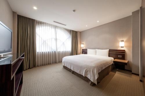 新竹迎曦大饭店的酒店客房,配有床和电视