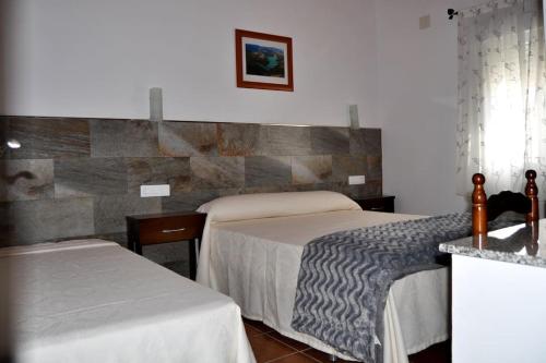 波索阿尔孔Casa rural Molino S CAZORLA PISCINA COMPARTIDA的酒店客房设有两张床和柜台。