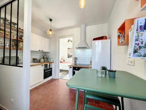 日安Studio LE VINTAGE - Maison 1911 - confort & prestige的厨房配有绿桌和冰箱。