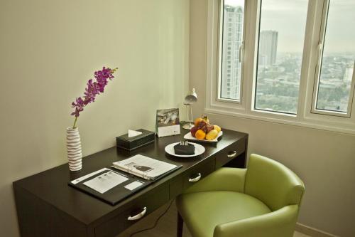 马尼拉The Exchange Regency Residence Hotel Managed by HII的一张带绿椅和花瓶的桌子
