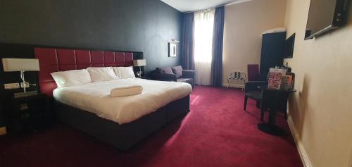 坎伯恩约翰弗朗西斯巴塞特韦瑟斯彭酒店的酒店客房带一张大床和一把椅子