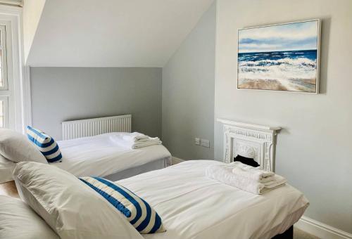克罗默Coast House Cromer - Sleeps 15, hot tub, sea views的带壁炉的客房内的两张床