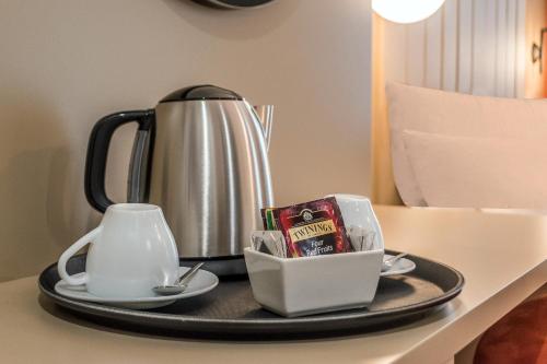 米兰BB Hotels Smarthotel Duomo的一个带茶壶和糖果的托盘