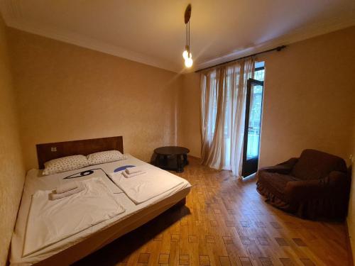 第比利斯Benevo Hostel的卧室配有床、椅子和窗户。
