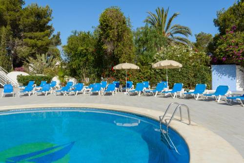圣安东尼奥湾Hotel Apartamentos Vibra Monterrey的一个带蓝色躺椅和遮阳伞的游泳池