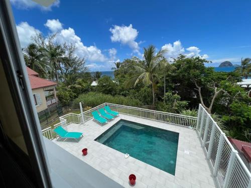 勒迪亚芒Villa en bord de mer, vue mer au Diamant的从房子里可欣赏到游泳池的景色