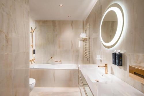 布拉格布拉格河畔马梅森酒店的一间带水槽、卫生间和镜子的浴室