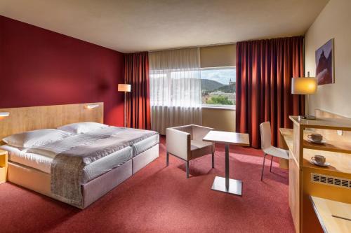 拉贝河畔乌斯季拉贝河畔乌斯季克拉丽奥酒店的配有一张床和一张书桌的酒店客房