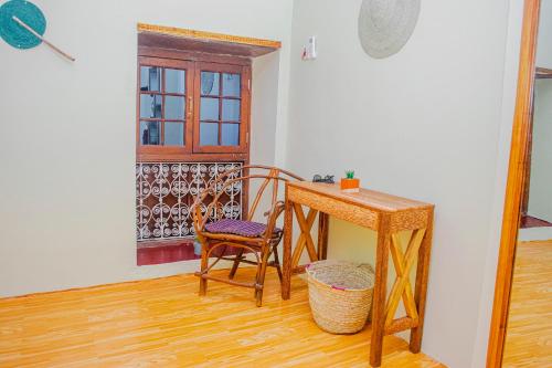 Stone TownZanzibar Spice Nest Apartment的客房设有书桌、椅子和桌子。