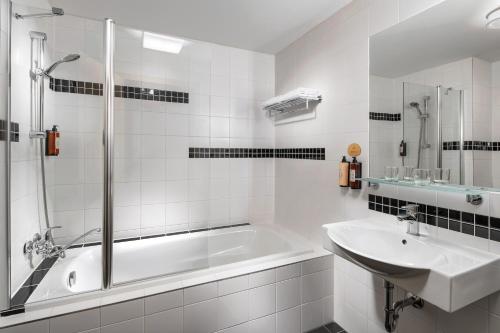 拉贝河畔乌斯季拉贝河畔乌斯季克拉丽奥酒店的白色的浴室设有浴缸和水槽。