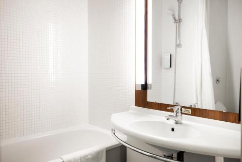 史云顿钟楼史云顿酒店的白色的浴室设有水槽和浴缸。