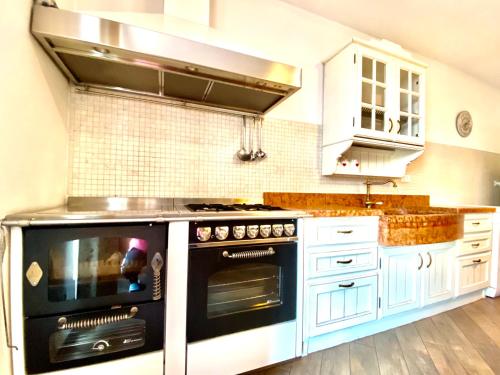 莱维科特尔梅APPARTAMENTO ELISA的厨房配有黑烤箱和白色橱柜。