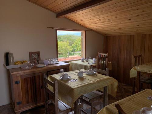 蒂拉登特斯Astral de Minas的一间设有两张桌子和窗户的用餐室