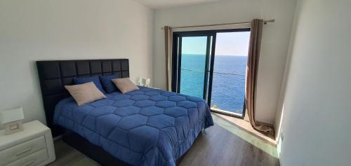 圣克鲁斯Apartamento T2-5m Aeroporto CR7的一间卧室设有蓝色的床和大窗户