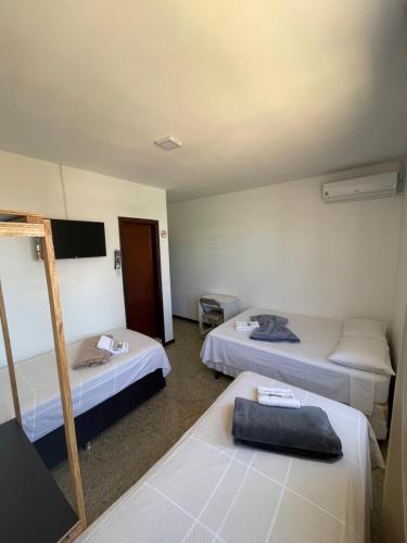 巴西利亚Pousada Vitória da Vila的酒店客房设有三张床和电视。