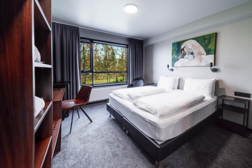 雷克霍特Blue Hotel Fagrilundur - On The Golden Circle的一间卧室配有一张床、一张书桌和一个窗户。