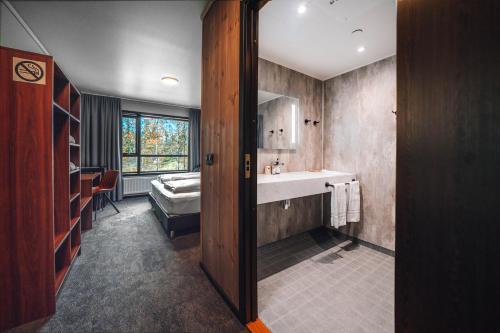 雷克霍特Blue Hotel Fagrilundur - On The Golden Circle的一间带水槽的浴室和一张位于客房内的床