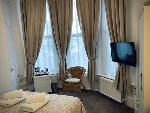 伦敦盖特威酒店的一间卧室设有两张床、一台电视和窗户。