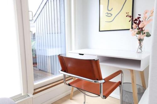 赫尔辛基2ndhomes Unique 35m2 Studio Penthouse with Sauna & Balcony的一张白色的桌子,椅子旁边是窗口