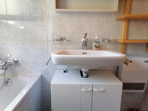 Nandagon Gasthouse的浴室配有白色水槽和浴缸。