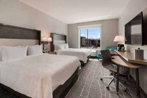 蒙特朱丽叶Holiday Inn & Suites - Mt Juliet Nashville Area, an IHG Hotel的酒店客房配有两张床和一张书桌