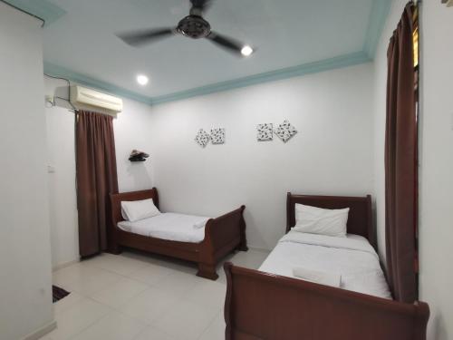 瓜拉丁加奴RVH Kuala Terengganu的一间设有两张床和椅子的房间