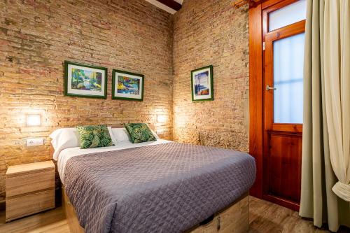 瓦伦西亚巴伦西亚中心皮耶拉公寓的一间卧室设有一张床和砖墙