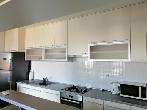 乌马格Apartment Bencic的厨房配有白色橱柜和炉灶烤箱。