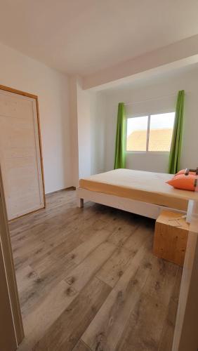 PalmeiraBaia Palmeira Residence的一间卧室设有一张床和一个窗口