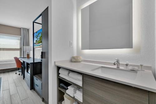南帕诸岛Comfort Inn的一间带镜子和盥洗盆的浴室以及一张书桌