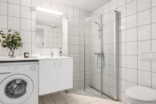 贝特斯托尔Leilighet Beitostølen sentrum, terrasse og innendørs parkering的白色的浴室设有洗衣机和淋浴。