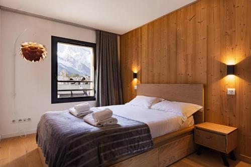 夏蒙尼-勃朗峰Modern 2BR 5* pool gym spa garage Mont-Blanc view的一间卧室配有带毛巾的床
