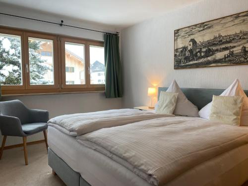 巴特维塞Apartmenthaus am Tegernsee - Studios mit Küchenzeile und mit Bus erreichbar的一间卧室配有一张大床和一把椅子