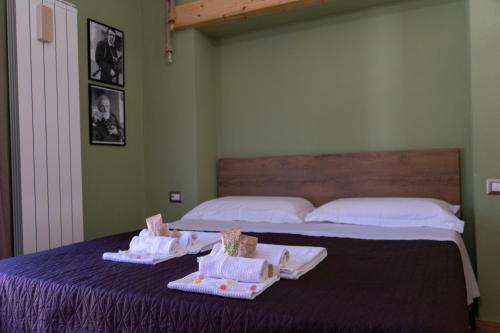 卡斯泰尔梅扎诺B&B Sud e Magia的一间卧室配有两张床,桌子上配有毛巾