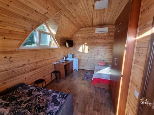 Krasnaya SlobodkaШафран的小木屋内的卧室,配有一张床和一张书桌