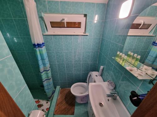 Krasnaya SlobodkaШафран的绿色瓷砖浴室设有卫生间和水槽