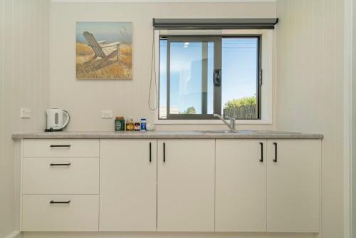 怀蒂昂格Rooftops Accommodation的厨房设有水槽和窗户。