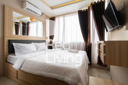 ParungmalelaRedLiving Apartemen at Saladdin - RAN的一间卧室设有一张床、电视和窗户