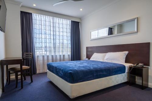 珀斯珀斯格蕾特南部酒店的一间卧室配有一张床、一张书桌和一个窗户。