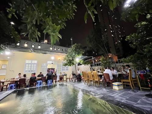 芽庄Garden House Nha Trang的一群人晚上坐在游泳池周围