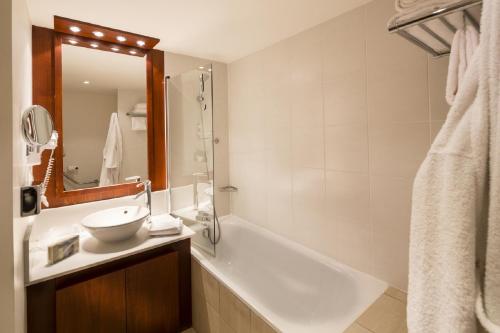 库尔布瓦库尔布瓦拉德芳斯公寓式酒店的带浴缸、水槽和镜子的浴室